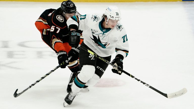 San Jose Sharks' Nikolai Knyzhov, right, moves the puck past Anaheim Ducks' Rickard Rakell during the first period of an NHL hockey game Saturday, Feb. 6, 2021, in Anaheim, Calif. (Jae C. Hong/AP)