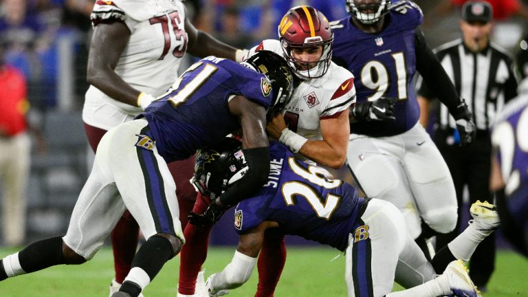 Washington Commanders quarterback Sam Howell, center, is sacked by Baltimore Ravens linebacker Jeremiah Moon, left, and safety Geno Stone in the second half of a preseason NFL football game, Saturday, Aug. 27, 2022, in Baltimore. (Nick Wass/AP)