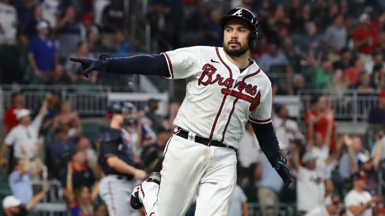 Fans cheer while Atlanta Braves' Travis d'Arnaud point to the dugout after hitting a two-run home run against the Washington Nationals during the fourth inning of a baseball game Tuesday, Sept. 20, 2022, in Atlanta. (Curtis Compton/Atlanta Journal-Constitution via AP)