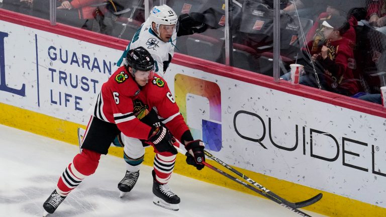 Chicago Blackhawks defenseman Jake McCabe, left, and San Jose Sharks center Nick Bonino battle for the puck during the first period of an NHL hockey game in Chicago, Thursday, April 14, 2022. (AP Photo/Nam Y. Huh)