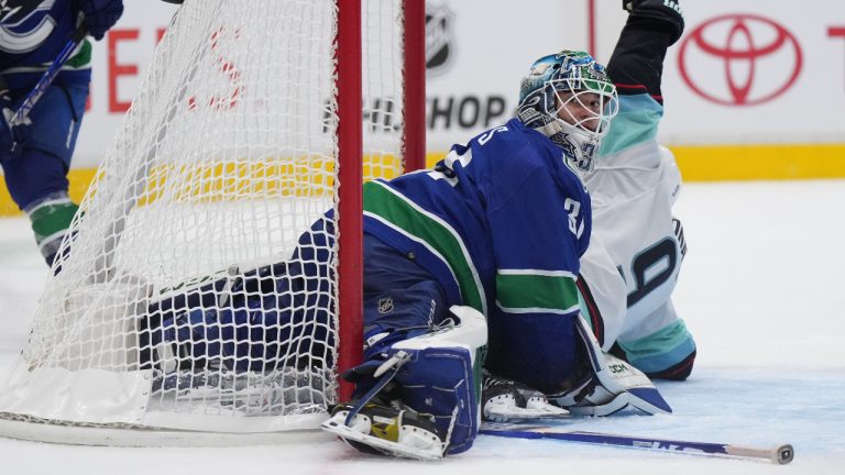 Vancouver Canucks goalie Arturs Silovs, of Latvia, looks at the referee as Seattle Kraken's Ryan Donato, back right, celebrates his winning goal during overtime NHL hockey acton in Vancouver, on Thursday, September 29, 2022. (Darryl Dyck/CP)