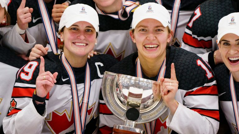 Canada's Marie-Philip Poulin, left, and Brianne Jenner, centre, hold the trophy after The IIHF World Championship Woman's ice hockey gold medal match between USA and Canada in Herning, Denmark, Sunday, Sept. 4, 2022. (Bo Amstrup/Ritzau Scanpix via AP)