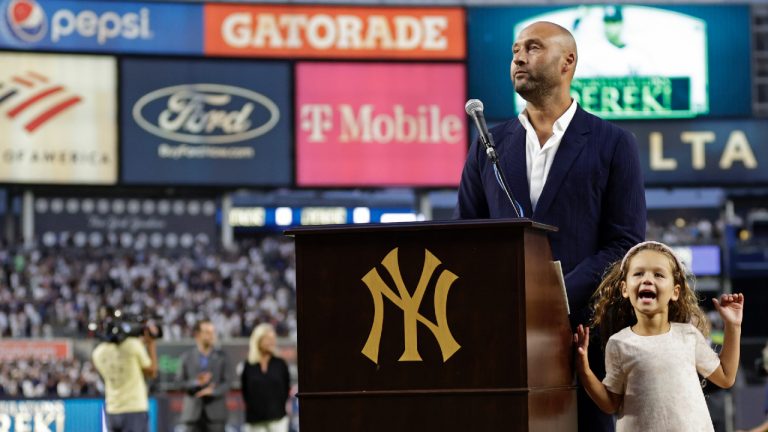 Baseball Hall of Famer Derek Jeter speaks as his daughter Bella Raine smiles by his side during a ceremony honoring his Hall of Fame induction last year, before a baseball game between the Tampa Bay Rays and the New York Yankees on Friday, Sept. 9, 2022, in New York. (Adam Hunger/AP)