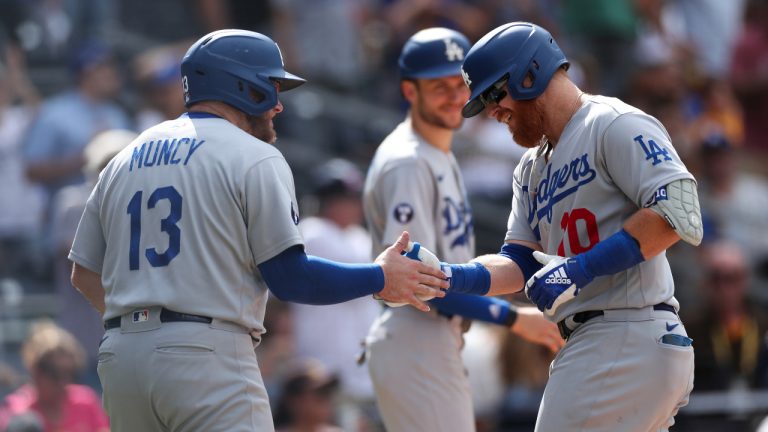 Los Angeles Dodgers' Justin Turner, right, is congratulated by Max Muncy after hitting a grand slam against the San Diego Padres in the seventh inning of a baseball game Sunday, Sept. 11, 2022, in San Diego. (Derrick Tuskan/AP)