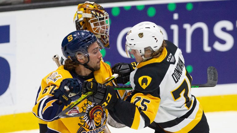 Shawinigan Cataractes' Daniel Agostino (67) takes a crosscheck from Hamilton Bulldogs' Jorian Donovan (75) during first period CHL Memorial Cup hockey action, in Saint John, N.B., Monday, June 27, 2022. (Ron Ward/CP)