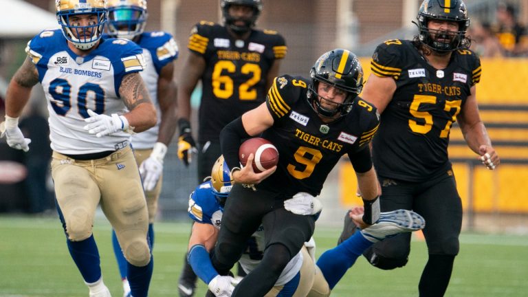 Hamilton Tiger Cats quarterback Dane Evans (9) keeps the ball and runs for a first down during second half CFL football game action against the Winnipeg Blue Bombers in Hamilton, Ont. on Saturday, September 17, 2022. (Peter Power/THE CANADIAN PRESS)