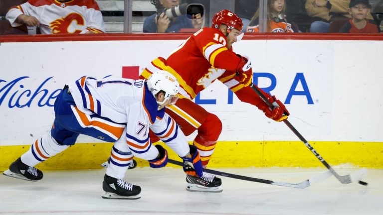 Edmonton Oilers forward Ryan Mcleod, left, checks Calgary Flames forward Jonathan Huberdeau during second period NHL pre-season hockey action in Calgary, Wednesday, Sept. 28, 2022. (Jeff McIntosh/THE CANADIAN PRESS)