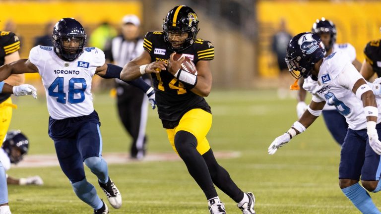 Hamilton Tiger-Cats quarterback Jamie Newman (14) carries the ball during second half CFL football game action against the Toronto Argonauts in Hamilton, Ont. on Friday, August 12, 2022. (Nick Iwanyshyn/THE CANADIAN PRESS)