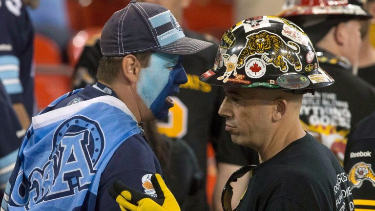 Toronto Argonauts and Hamilton Tiger-Cats fans exchange views as they watch second half CFL football action in Toronto on Thursday June 23, 2016. (Chris Young/THE CANADIAN PRESS)