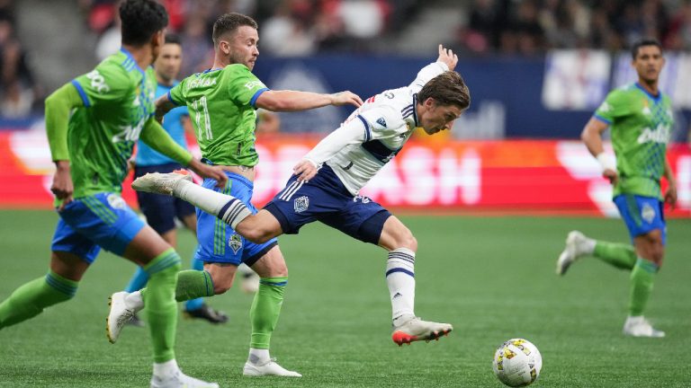 Vancouver Whitecaps' Ryan Gauld, centre, and Seattle Sounders' Albert Rusnak, back left, vie for the ball during the second half of an MLS soccer game in Vancouver, on Saturday, September 17, 2022. (Darryl Dyck/CP)