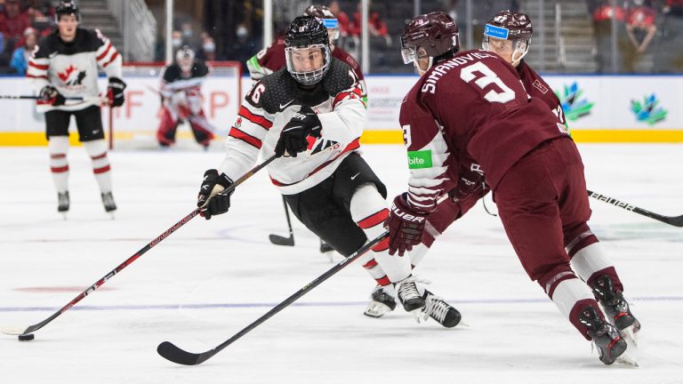 Canada's Connor Bedard (16) makes a move past Latvia's Rihards Simanovics (3) during second period IIHF World Junior Hockey Championship action in Edmonton on Wednesday, August 10, 2022. (Jason Franson/CP)