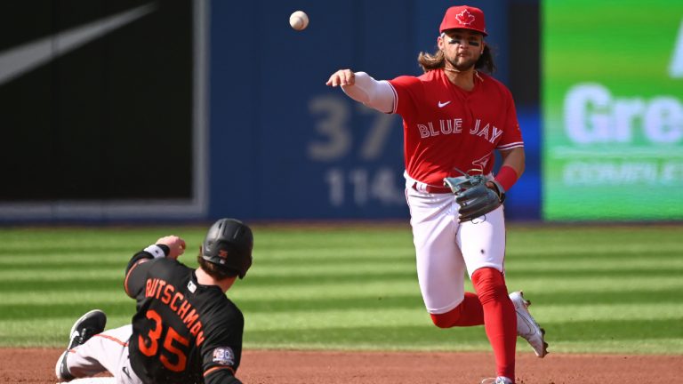 Toronto Blue Jays’ shortstop Bo Bichette, right, throws to first base to put out Baltimore Orioles’ Anthony Santander after forcing out Adley Rutschman (35) in first inning American League baseball action in Toronto, Saturday, Sept. 17, 2022. (Jon Blacker/CP)