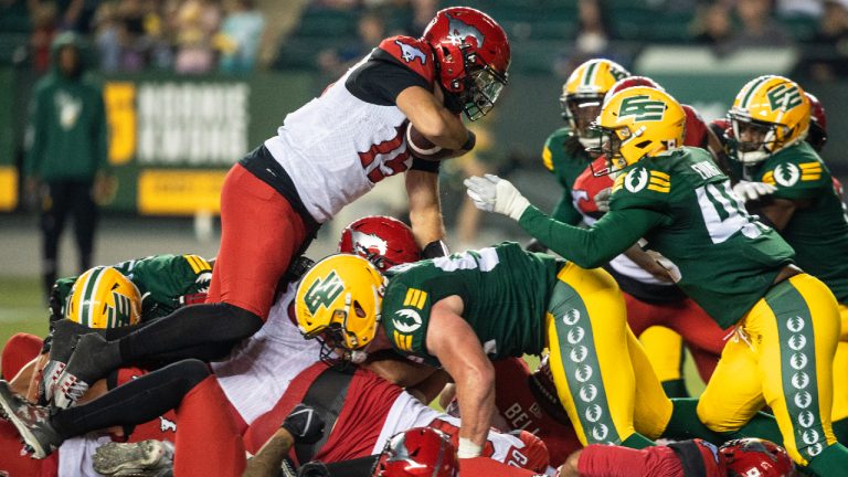 Calgary Stampeders quarterback Tommy Stevens (15) jumps over the pile against the Edmonton Elks during second half CFL action in Edmonton, Alta., on Saturday September 10, 2022. (Jason Franson/CP)