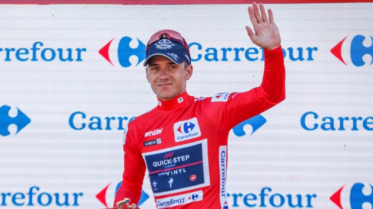 Belgian Remco Evenepoel of Quick-Step Alpha Viny celebrates on the podium in the red jersey for leader in the overall ranking after the 16th stage during the Vuelta cycling race between San Lucar de Barrameda and Tomares, in Tomares, southern Spain, Tuesday, Sept. 6, 2022. (Angel Fernandez/AP)