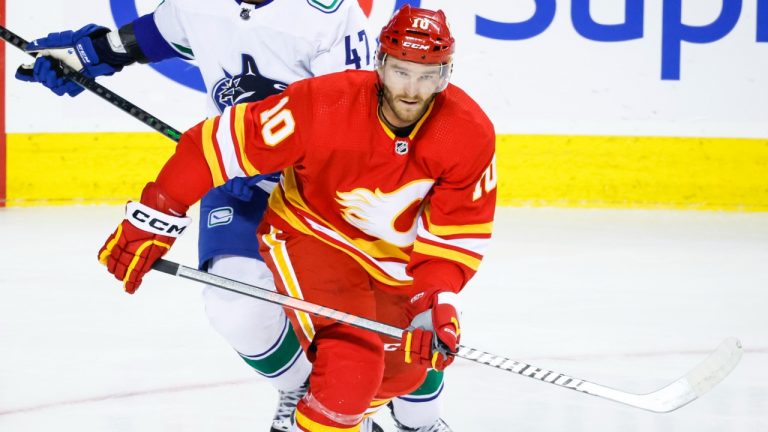 Vancouver Canucks defenceman Noah Juulsen, left, and Calgary Flames forward Jonathan Huberdeau chase the puck during first period NHL pre-season hockey action in Calgary, Alta., Sunday, Sept. 25, 2022. (Jeff McIntosh/CP)