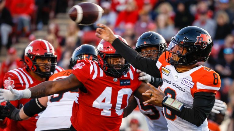 BC Lions quarterback Vernon Adams, right, throws the ball as Calgary Stampeders defensive lineman Shawn Lemon closes in during second half CFL football action in Calgary, Saturday, Sept. 17, 2022. (Jeff McIntosh/CP)