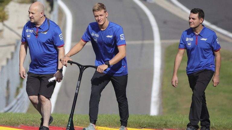 Haas driver Mick Schumacher of Germany, center, walks on the track with his team ahead of the Formula One Grand Prix at the Spa-Francorchamps racetrack. (Olivier Matthys/AP)