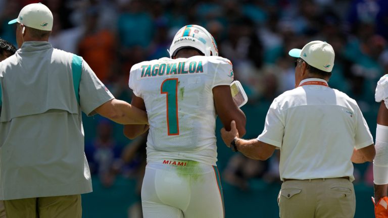 Miami Dolphins quarterback Tua Tagovailoa (1) is assisted off the field during the first half of an NFL football game against the Buffalo Bills. (Rebecca Blackwell/AP)