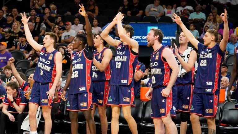 Adelaide 36ers bench players celebrate a lead on the Phoenix Suns during the first half of an NBA preseason basketball game Sunday. (Darryl Webb/AP)