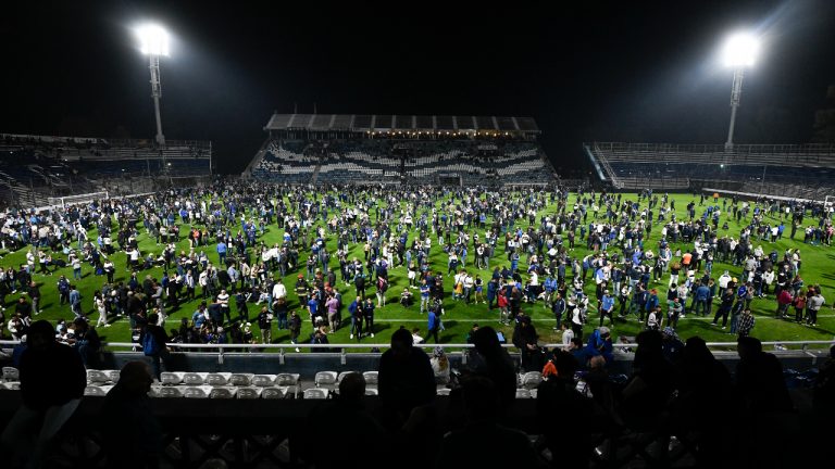 Fans of Gimnasia de La Plata take to the pitch after tear gas invaded the field during a local tournament match between Gimnasia de La Plata and Boca Juniors in La Plata, Argentina. (Gustavo Garello/AP)