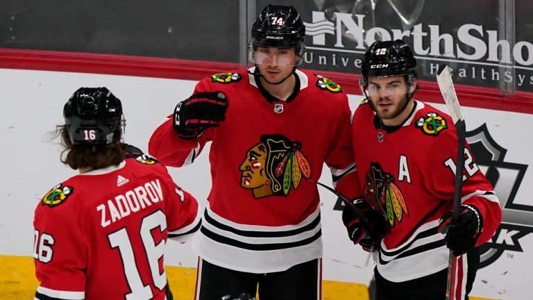 Chicago Blackhawks' Nicolas Beaudin, center, celebrates with Nikita Zadorov, left, and Alex DeBrincat after scoring a goal during the second period of an NHL hockey game against the Columbus Blue Jackets in Chicago, Saturday, Feb. 13, 2021. (Nam Y. Huh/AP Photo)