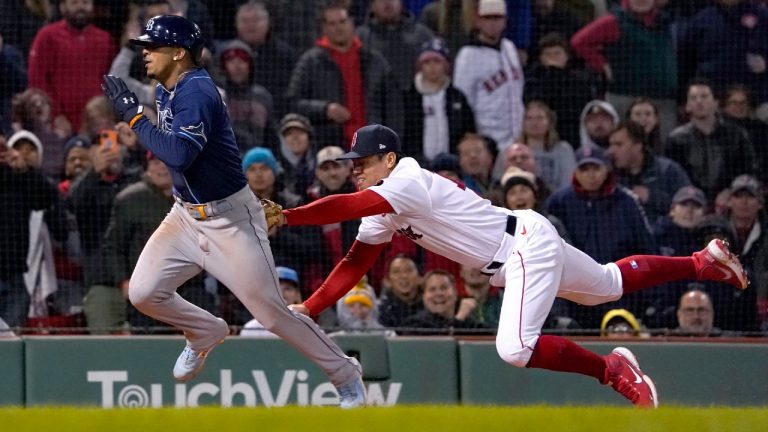 Boston Red Sox shortstop Yu Chang, right, dives to tag Tampa Bay Rays' Wander Franco as Franco caught in a rundown between third and home during the ninth inning of a baseball game at Fenway Park, Monday, Oct. 3, 2022, in Boston. (Mary Schwalm/AP)