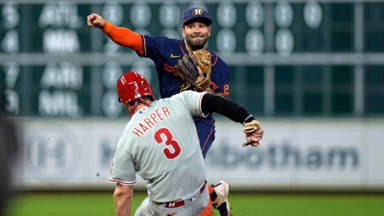 Houston Astros second baseman Jose Altuve, top, throws to first for a double play as Philadelphia Phillies' Bryce Harper (3) slides into second base during the fourth inning of a baseball game Monday, Oct. 3, 2022, in Houston. (David J. Phillip/AP)