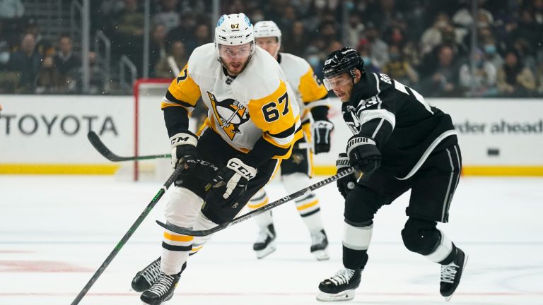 Pittsburgh Penguins' Radim Zohorna, left, moves the puck past Los Angeles Kings' Dustin Brown during the first period of an NHL hockey game Thursday, Jan. 13, 2022, in Los Angeles. (AP Photo/Jae C. Hong)