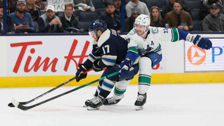 Columbus Blue Jackets' Justin Danforth, left, keeps the puck away from Vancouver Canucks' Oliver Ekman-Larsson during the second period of an NHL hockey game Tuesday, Oct. 18, 2022, in Columbus, Ohio. (AP)