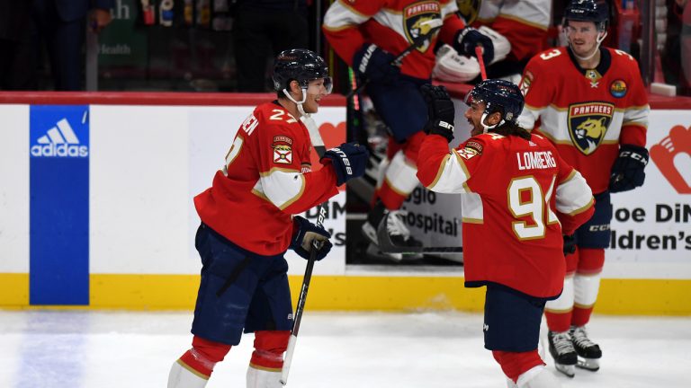 Florida Panthers' Eetu Luostarinen (27) and Ryan Lomberg (94) celebrate beating the New York Islanders 3-2 in an NHL hockey game, Sunday, Oct. 23, 2022, in Sunrise, Fla. (AP Photo/Michael Laughlin)