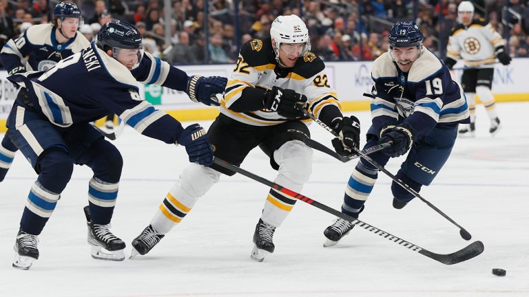 Boston Bruins' Tomas Nosek, center, tries to skate between Columbus Blue Jackets' Zach Werenski, left, and Liam Foudy during the third period of an NHL hockey game Friday, Oct. 28, 2022, in Columbus, Ohio. (Jay LaPrete/AP)