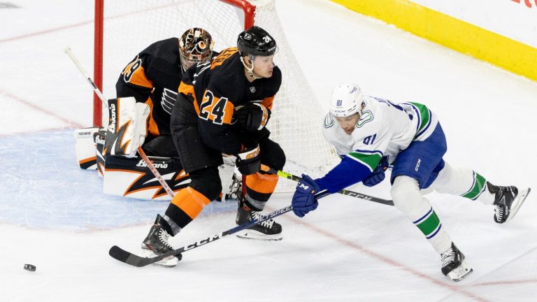 Vancouver Canucks center Dakota Joshua (81) tries to get the puck past Philadelphia Flyers defenseman Nick Seeler (24) during the first period of an NHL hockey game, Saturday, Oct. 15, 2022, in Philadelphia. (Laurence Kesterson/AP Photo)