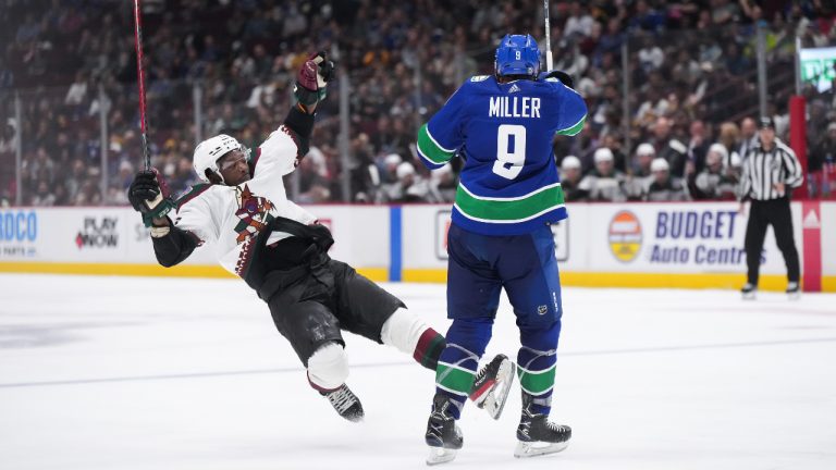 Vancouver Canucks' J.T. Miller (9) checks Arizona Coyotes' Bokondji Imama during the third period of a pre-season NHL hockey game in Vancouver, on Friday, October 7, 2022. (Darryl Dyck/CP)