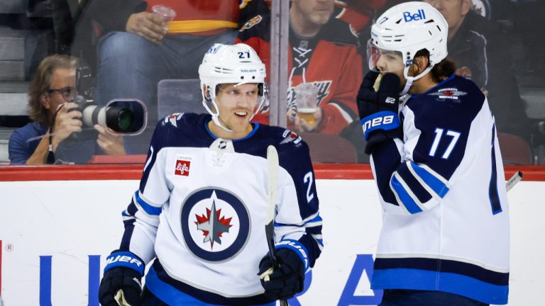 Winnipeg Jets forward Nikolaj Ehlers, left, celebrates his goal with teammate Adam Lowry during first period NHL pre-season hockey action against the Calgary Flames in Calgary, Friday, Oct. 7, 2022. (Jeff McIntosh/CP)