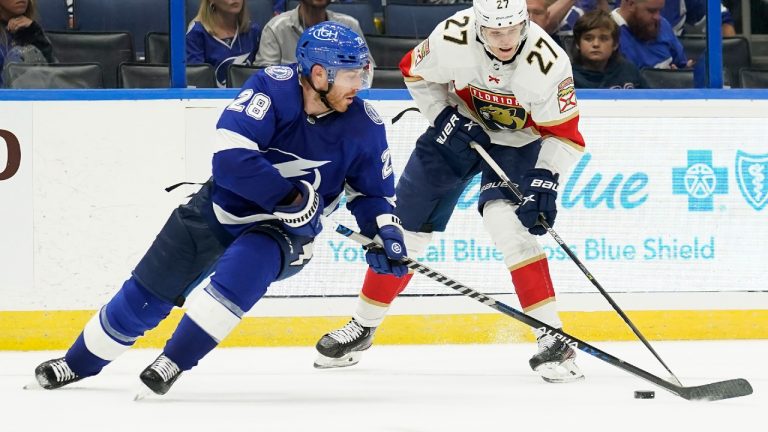 Florida Panthers center Eetu Luostarinen (27) works around Tampa Bay Lightning defenseman Ian Cole (28) during the third period of an NHL preseason hockey game Saturday, Oct. 8, 2022, in Tampa, Fla. (Chris O'Meara/AP)