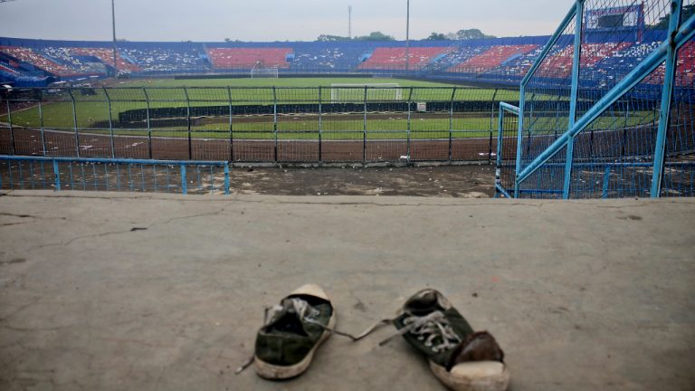 A pair of sneakers sit trampled in the stands of Kanjuruhan Stadium following a deadly soccer match stampede, in Malang, East Java, Indonesia, Sunday, Oct. 2, 2022. Panic at an Indonesian soccer match after police fired tear gas to to disperse supporters invading the pitch left over 100 people dead, mostly trampled to death, police said Sunday. (AP Photo/Hendra Permana)