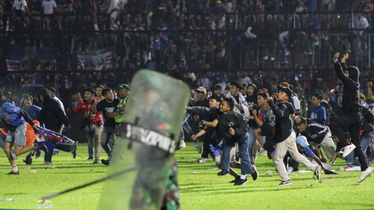 Soccer fans enter the pitch during a clash between supporters at Kanjuruhan Stadium in Malang, East Java, Indonesia, Saturday, Oct. 1, 2022. (Yudha Prabowo/AP)