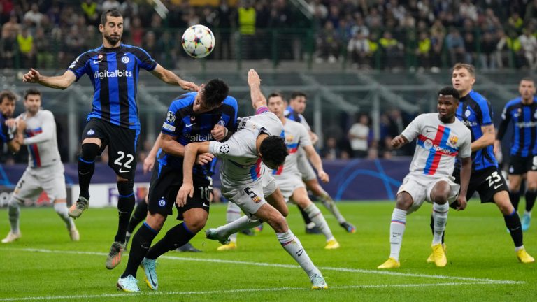 Barcelona's Sergio Busquets fights for the ball against Inter Milan's Lautaro Martinez and Milan's Henrikh Mkhitaryan during the Champions League group C soccer match between Inter Milan and Barcelona at the San Siro stadium in Milan, Italy, Tuesday, Oct. 4, 2022. (Antonio Calanni/AP)