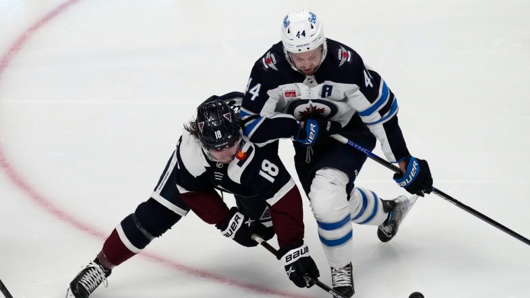 Colorado Avalanche center Alex Newhook, left, vies for control of the puck against Winnipeg Jets defenseman Josh Morrissey during the first period of an NHL hockey game Wednesday, Oct. 19, 2022, in Denver. (David Zalubowski/AP Photo)