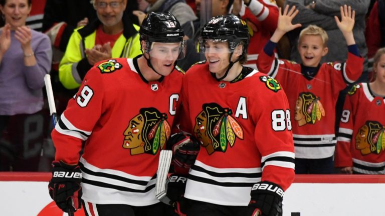 FILE - Chicago Blackhawks' Patrick Kane (88) celebrates with teammate Jonathan Toews (19) after scoring a hat trick during the third period of an NHL hockey game against the Minnesota Wild in Chicago, in this Sunday, Dec. 15, 2019, file photo. (AP Photo/Paul Beaty, File)