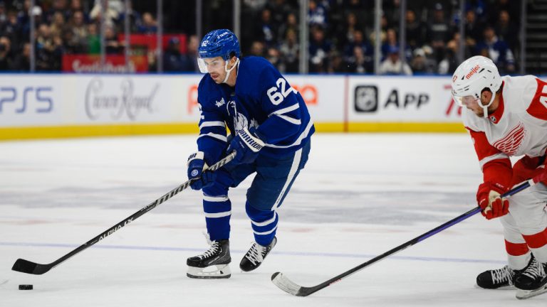 Toronto Maple Leafs centre Denis Malgin (62) moves the puck forward while defended by Detroit Red Wings defensemen Wyatt Newpower (47) during second period NHL pre-season action, in Toronto, on Saturday, October 8, 2022. (CP)