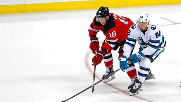 San Jose Sharks right wing Kevin Labanc (62) and New Jersey Devils left wing Ondrej Palat (18) battle for the puck during the third period of an NHL hockey game, Saturday, Oct. 22, 2022, in Newark, N.J. The Devils won 2-1. (Noah K. Murray/AP)