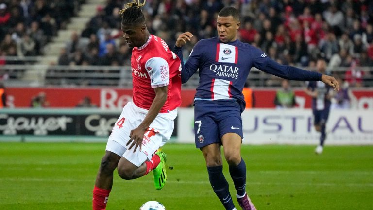 PSG's Kylian Mbappe, right, challenges Reims' Emmanuel Agbadou during a French League One soccer match between Reims and Paris Saint-Germain, at the Stade Auguste-Delaune in Reims, eastern France, Saturday, Oct. 8, 2022. (Michel Euler/AP)