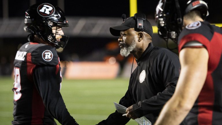 Ottawa Redblacks interim head coach Bob Dyce congratulates quarterback Nick Arbuckle (19) after a touchdown against the Montreal Alouettes during first half CFL football action in Ottawa on Oct. 14, 2022. After three straight seasons of falling far short of expectations, Redblacks general manager Shawn Burke will have his work cut out for him this off-season. Ottawa finished the 2022 season 4-14-0. (Justin Tang/CP)