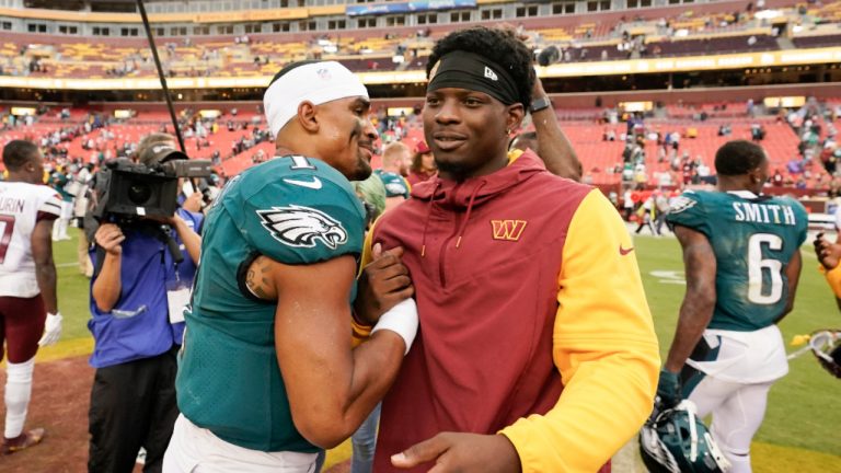 Philadelphia Eagles quarterback Jalen Hurts (1) stops to greet Washington Commanders injured running back Brian Robinson Jr., at the end of an NFL football game, Sunday, Sept. 25, 2022, in Landover, Md. Robinson was shot twice during an attempted carjacking in Washington on August 28th. (Alex Brandon/AP) 