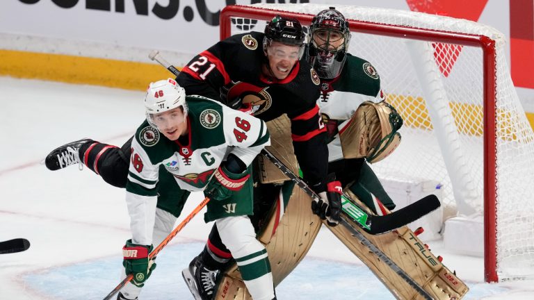 Minnesota Wild defenceman Jared Spurgeon keeps his eye on the puck as he ties up Ottawa Senators right wing Mathieu Joseph in front of goaltender Marc-Andre Fleury during second period NHL action, Thursday, October 27, 2022 in Ottawa. (Adrian Wyld/CP)