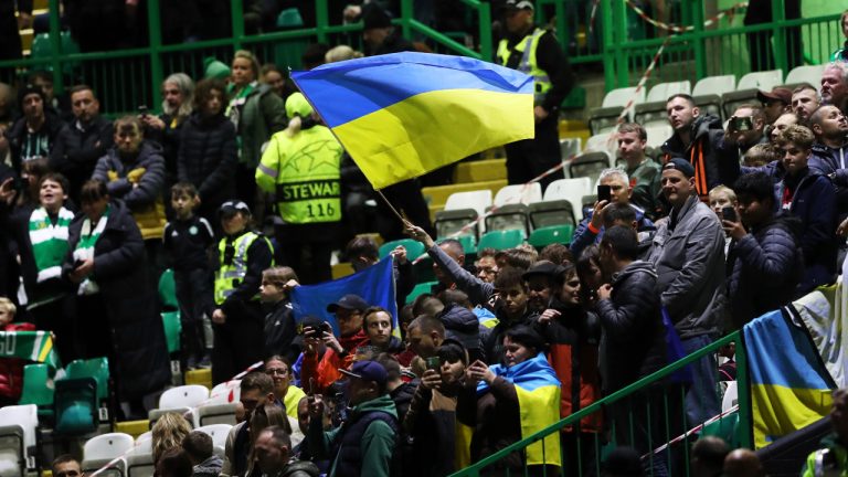 Spectators wave Ukrainian flag before the start of the Champions League Group F soccer match between Celtic and Shakhtar Donetsk at Celtic park, Glasgow, Scotland, Tuesday, Oct. 25, 2022. (AP Photo/Scott Heppell)