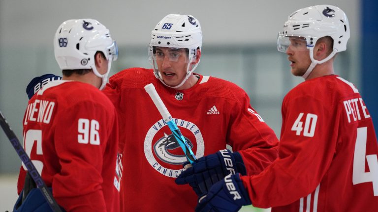 Vancouver Canucks' Ilya Mikheyev, centre, of Russia, talks to Andrei Kuzmenko, left, of Russia, and Elias Pettersson, of Sweden, during the NHL hockey team's training camp in Whistler, B.C., Thursday, Sept. 22, 2022. (Darryl Dyck/CP)