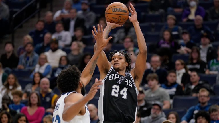 San Antonio Spurs guard Devin Vassell (24) shoots over Minnesota Timberwolves center Karl-Anthony Towns (32) during the second half of an NBA basketball game, Monday, Oct. 24, 2022, in Minneapolis. (Abbie Parr/AP)