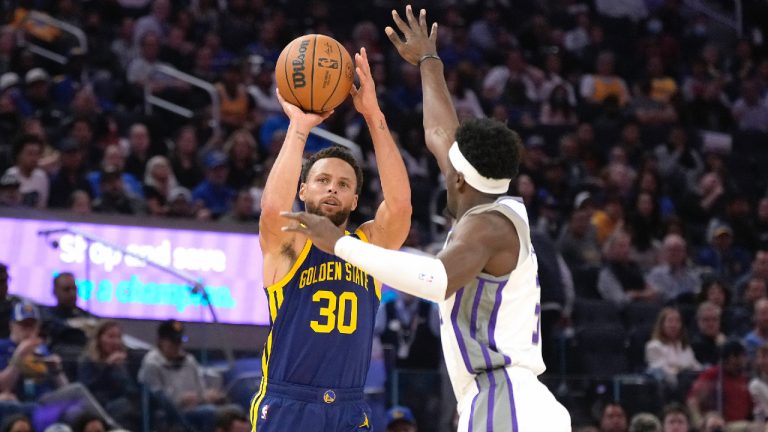 Golden State Warriors guard Stephen Curry (30) takes a 3-point shot over Sacramento Kings guard Terence Davis (3) during the second half of an NBA basketball game on Sunday, Oct. 23, 2022, in San Francisco. (Tony Avelar/AP)